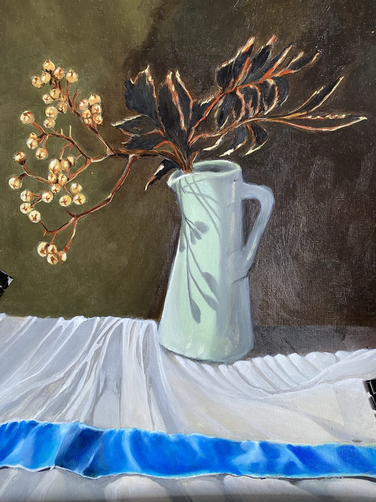 Watercolor of a white pitcher with forsythia on blue cloth