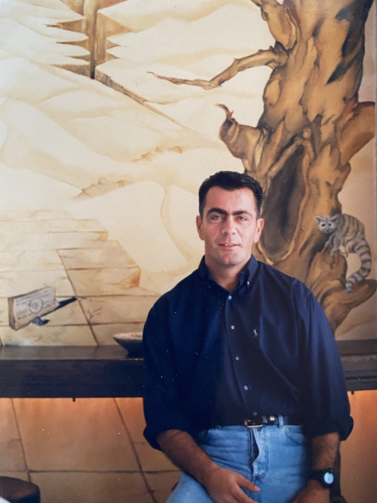 The artist in front of a finished mural